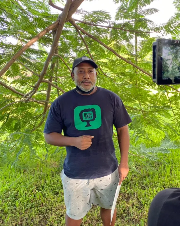 Christio Wijnhard presenting to camera among trees while a crew member films him on a phone