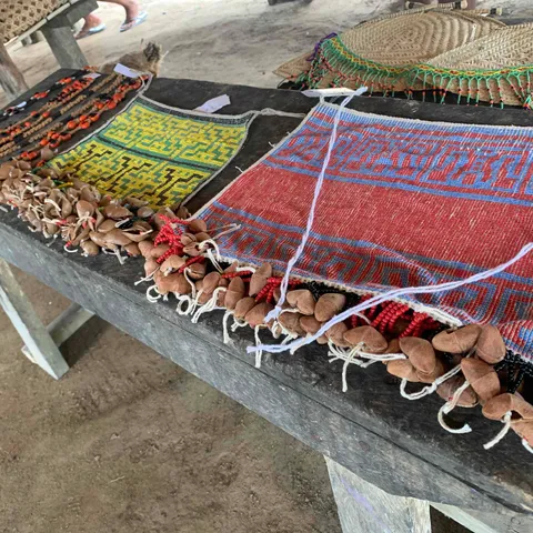 Woven bags, beadwork and other crafts laid out on a long table