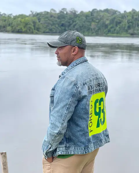 Dean Gorré by the river, wearing a denim jacket with the Forest93 logo on the back
