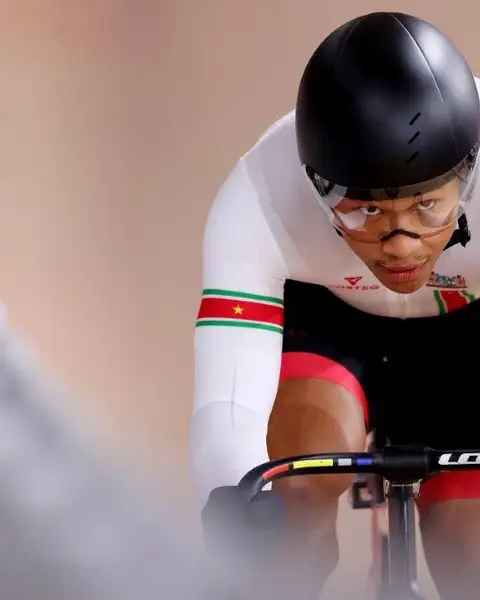 Jaïr Tjon En Fa racing on a track bike, wearing a helmet and the colours of Suriname