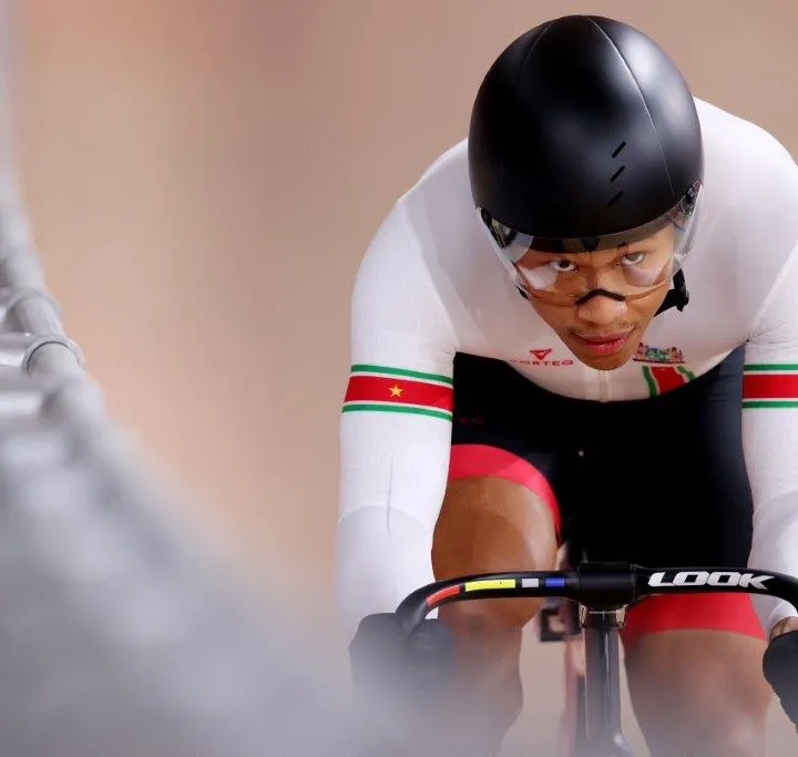Jaïr Tjon En Fa racing on a track bike, wearing a helmet and the colours of Suriname