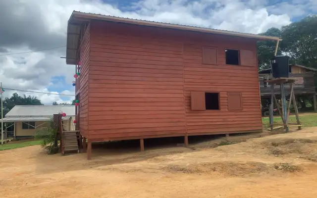 The new two-storey Tewe office in Kwamalasamutu, its red timber cladding strung with balloons for the opening in April 2025
