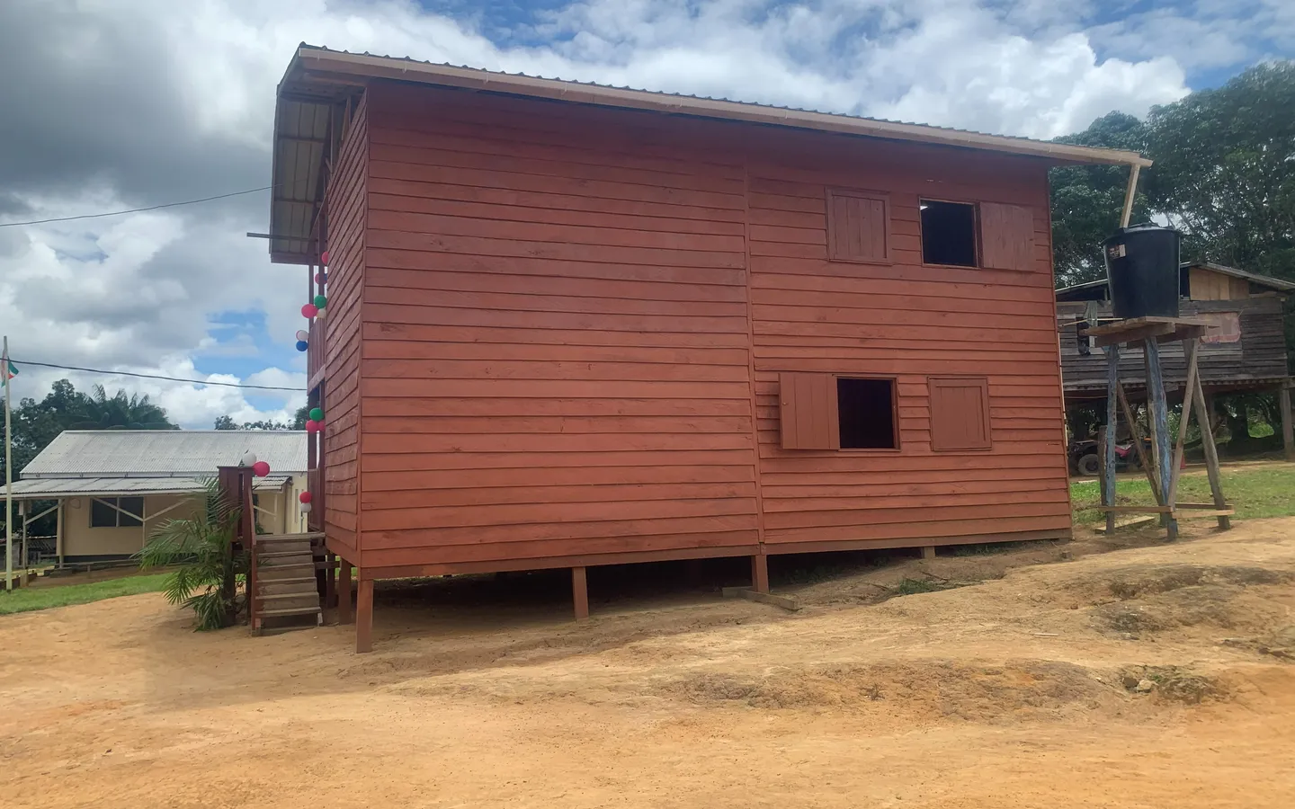 The new two-storey Tewe office in Kwamalasamutu, its red timber cladding strung with balloons for the opening in April 2025