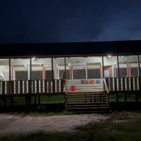 The school at Coeroeni after dark, lit from inside and along the length of its veranda