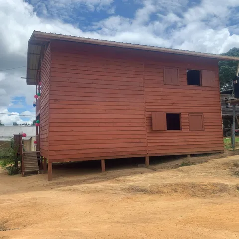 The new two-storey Stichting Tewe office in Kwamalasamutu, its red timber cladding strung with balloons for the opening in April 2025
